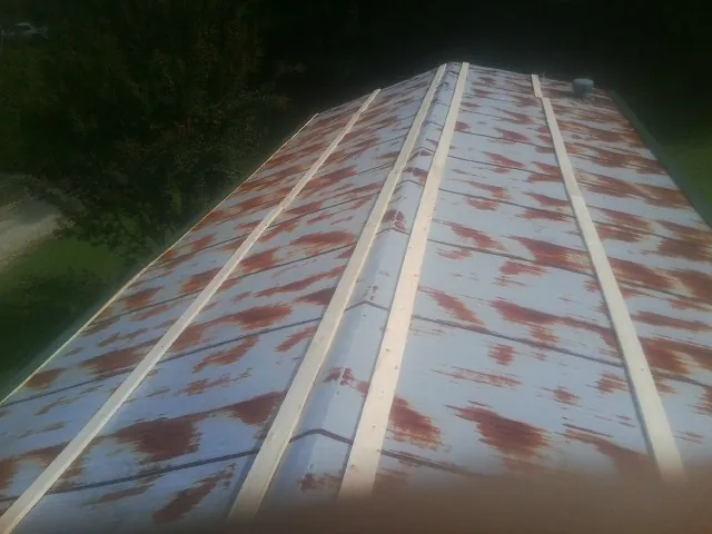 Rusted metal roof panels with new wood purlins before replacement — Storm Damage Roof Repair in Egg Harbor by Roofing Brothers