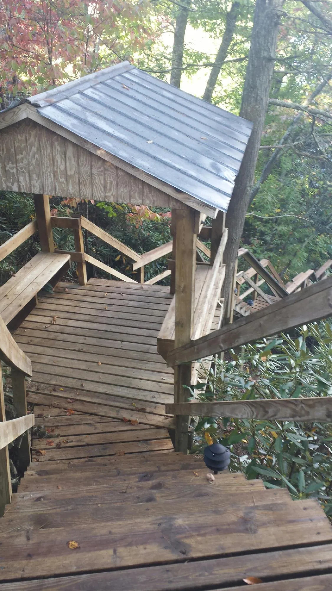Metal roofed shelter over wooden steps on a wooded walkway — Skylight Repair & Installation work by our crew in Egg Harbor